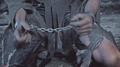 a prisoner in chains on his knees