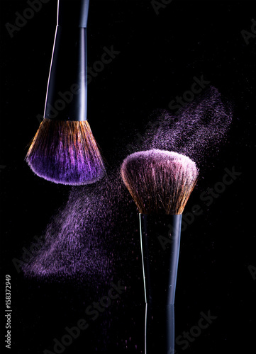 Brushes make-up and eyeshadow on a black background