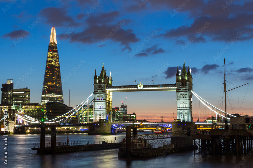 Tower Bridge, the Shard, city hall and business district in the background at night, London, Uk.