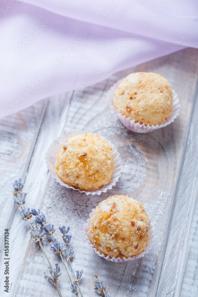 Fototapeta premium Homemade cream candy dessert on wooden background close up. Delicious praline with decor. Top view