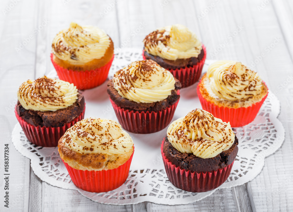 Tasty cupcakes with candies and chocolate on light background close up Tasty cupcakes with candies and chocolate on light background close up