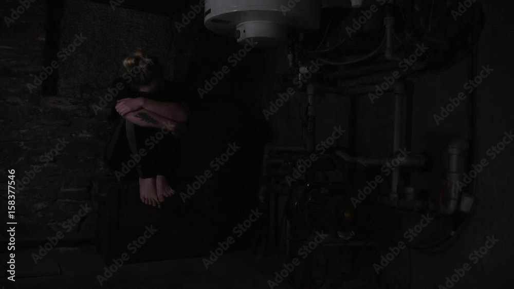 depressed anxious woman sitting in a dark corner of a basement, blinking overhead light depressed anxious woman sitting in a dark corner of a basement, blinking overhead light