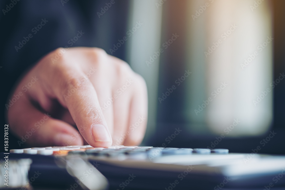 Closeup image of a business woman using calculator in office Closeup image of a business woman using calculator in office