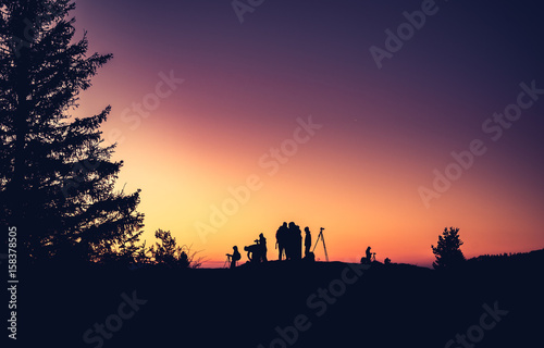 Silhouettes of unidentified photographers on the mountain peak in the morning