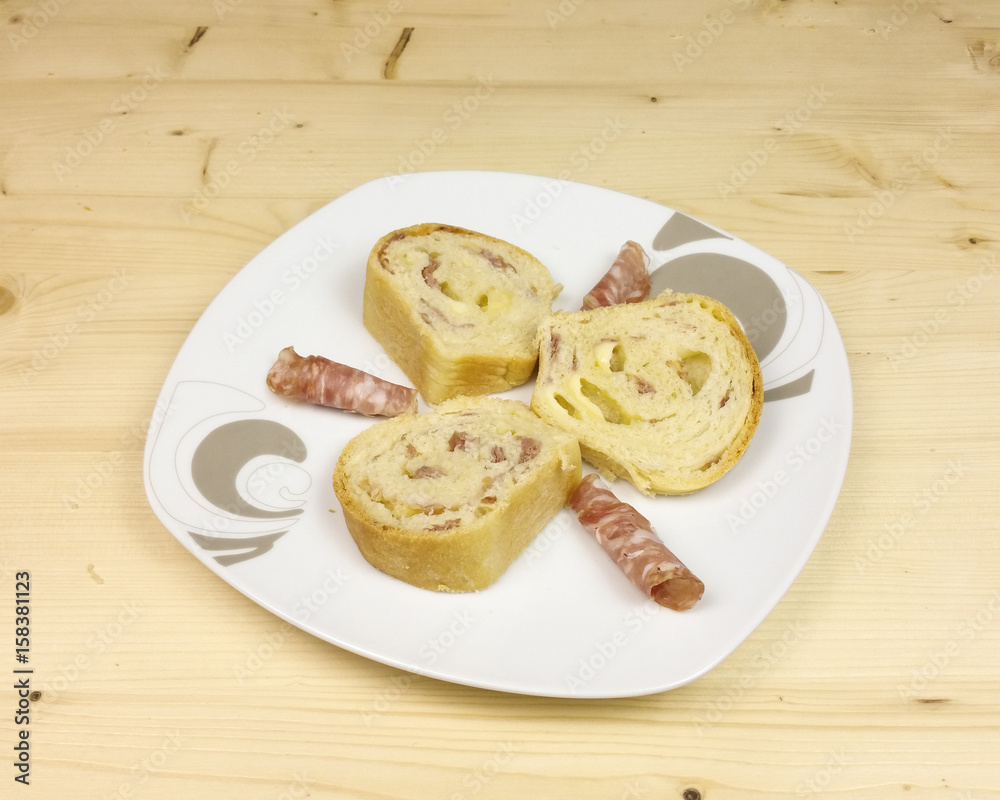 savory cake with salami, ham and cheese on wooden background - top view savory cake with salami, ham and cheese on wooden background - top view