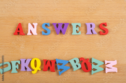 ANSWERS word on wooden background composed from colorful abc alphabet block wooden letters, copy space for ad text. Learning english concept.