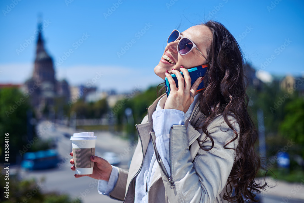 Pretty female talking on phone while drinking coffee Pretty female talking on phone while drinking coffee