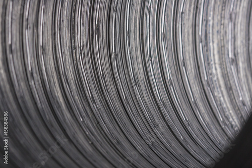 Metal background. Futuristic texture metal corrugated pipe. Circular strip on a metal surface