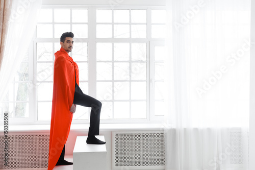 Businessman in red superhero cloak. Young man in suit and superman cape on stairs © lenblr