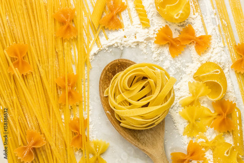 Vibrant pasta texture on white marble table with flour