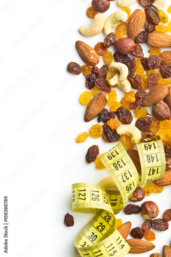 Obraz premium Various nuts and raisins with measuring tape.
