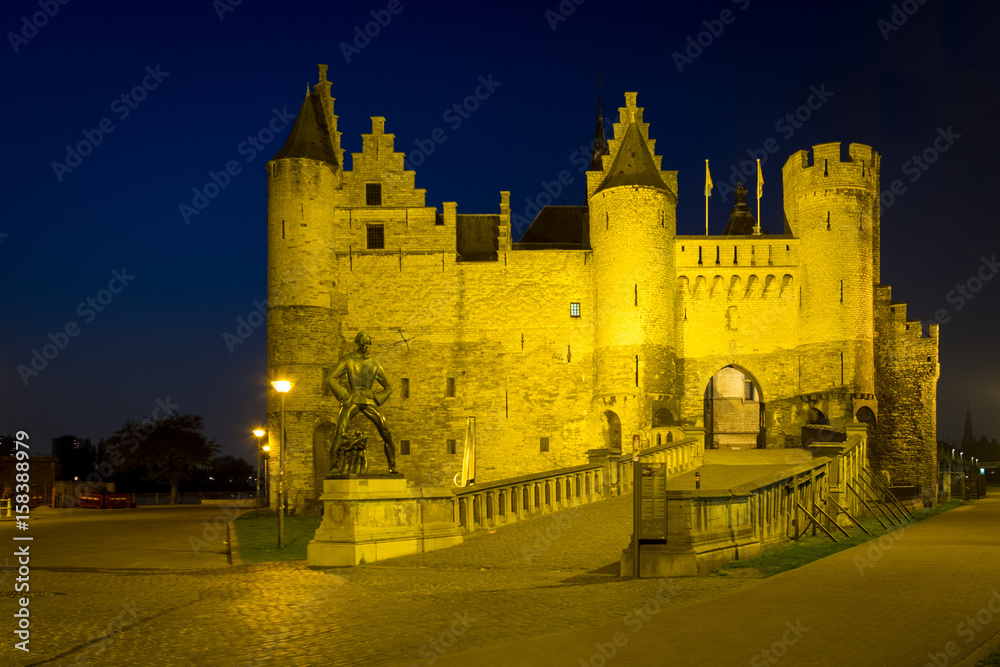 'Het Steen' fortress with the Lange Wapper monument during blue hour in Antwerp, Belgium.
