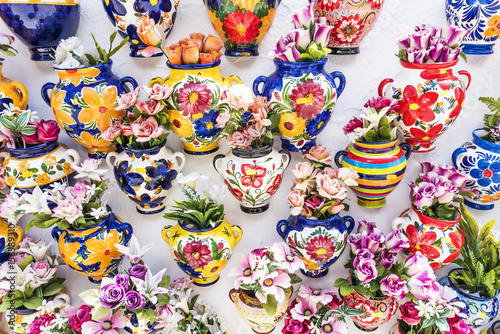Obraz na płótnie Colourful ceramic vases with flowers on a shop wall at Mijas