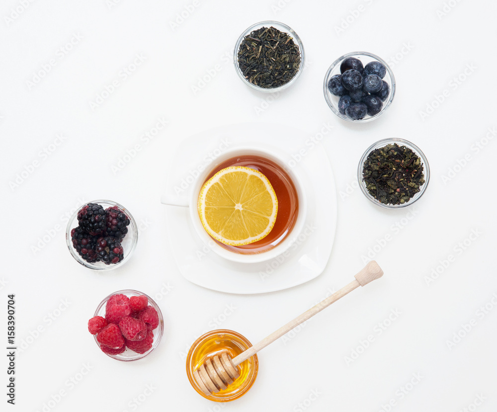 Herbal tea with honey, wild berry and flowers on white background. Flat lay, copy space Herbal tea with honey, wild berry and flowers on white background. Flat lay, copy space
