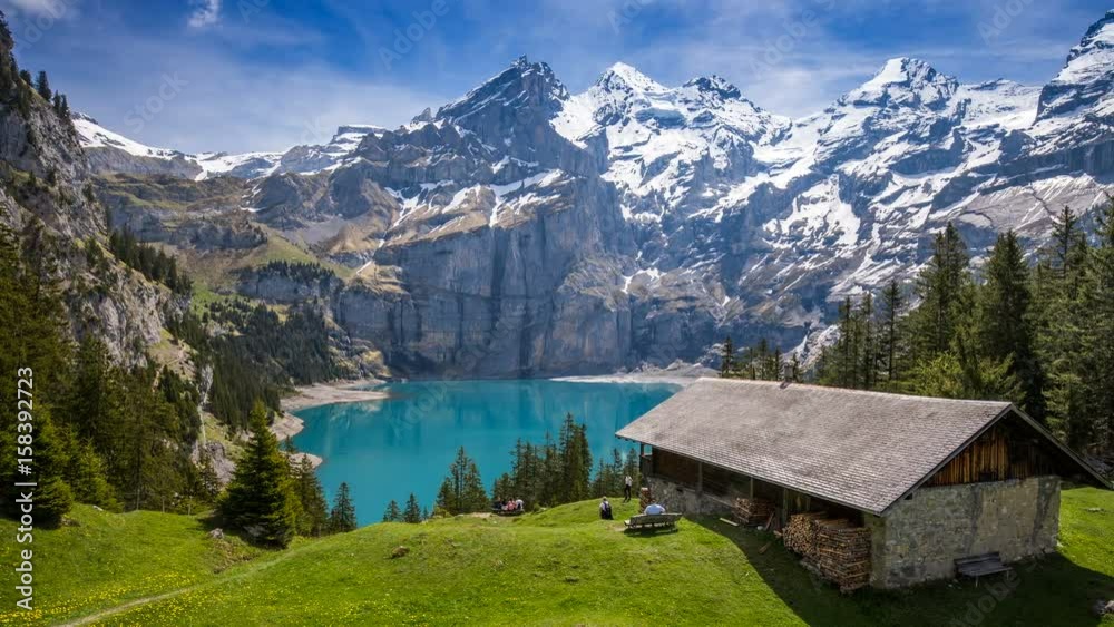 Amazing tourquise Oeschinnensee lake with waterfalls, wooden chalet and Swiss Alps, Berner Oberland, Switzerland. 
