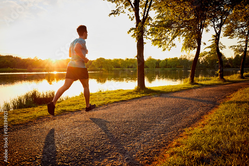 Young man jogging in park during sunset