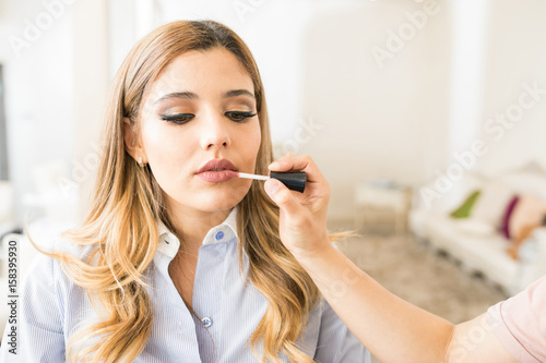 Woman getting some lipstick on in a salon
