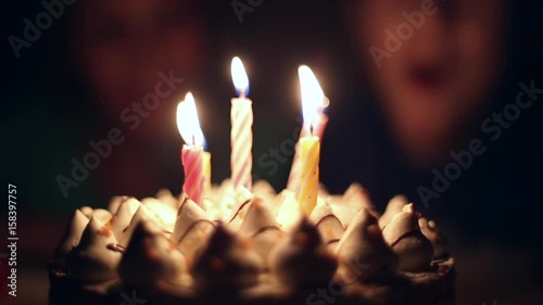 Light the candles on the cake, birthday boy makes a wish and blows out the candles on the cake in the dark