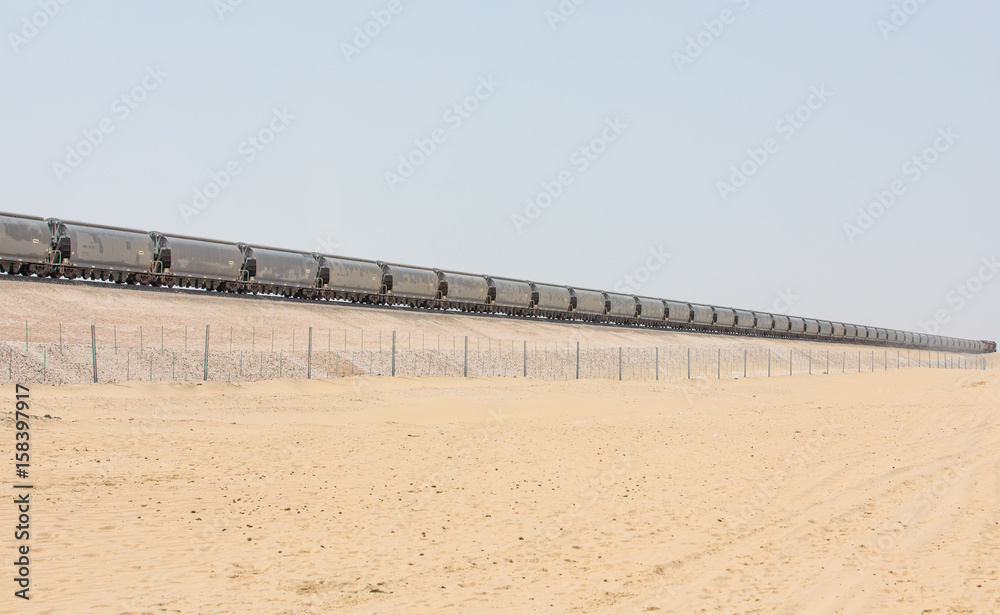 Train passing a railway in the desert.