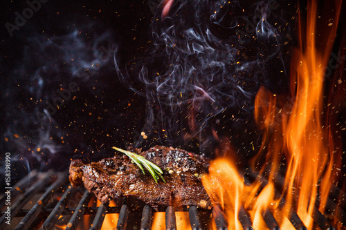 Beef steaks on the grill with flames © Lukas Gojda
