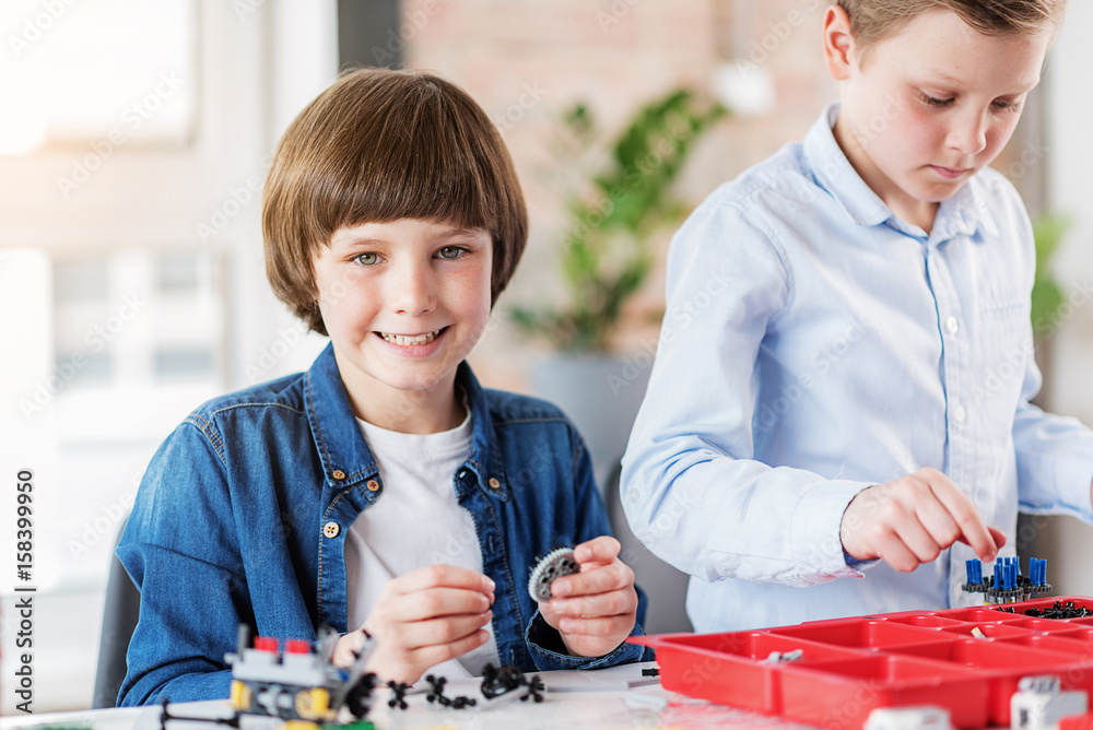 Cheerful smiling male child keeping detail Cheerful smiling male child keeping detail
