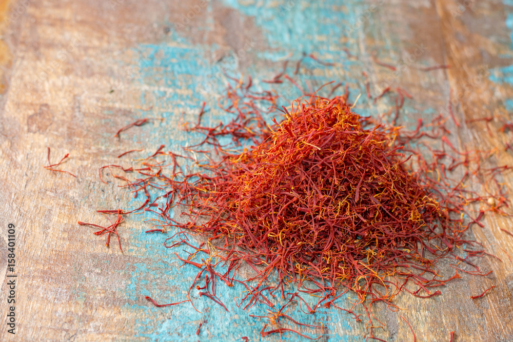 Fototapeta premium Dried organic red saffron Spice on wooden background