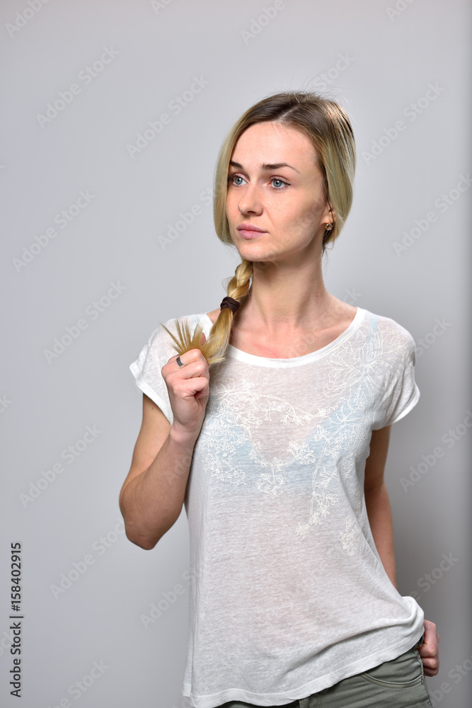 Blond girl, on white background, holds her dyed hair Blond girl, on white background, holds her dyed hair