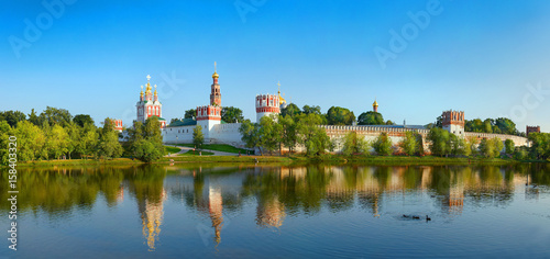 View on cloister monastery chapel walls  bell towers  pond with ducks. City park garden. Novodevichy Convent. Castle style monastery. Famous tourist sightseeing holidays vacations tours