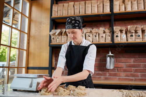 Woman forming taglatellein cafe photo