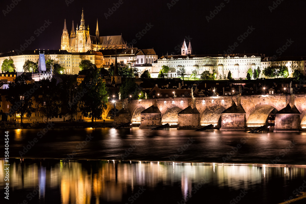 The Prague Castle and the Charles Bridge over Vltava river at night in Prague, Czech Republic