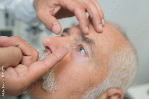Fototapeta Naklejka Na Ścianę i Meble -  Man having contact lens put in his eye