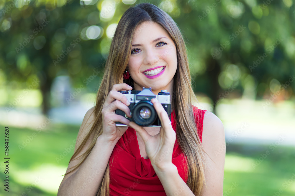 Young woman holding a camera outdoor