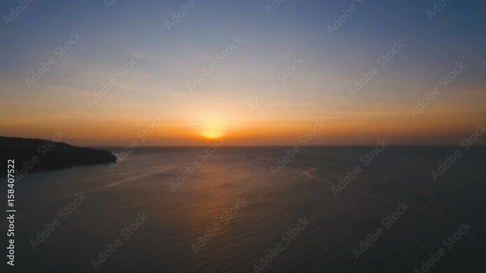 Marine tropical sunset over the sea. Aerial view: Sunset over the sea in the background orange sky and islands. Fly over the ocean in sunset time. Travel concept. Nothing but sky, clouds and water Marine tropical sunset over the sea. Aerial view: Sunset over the sea in the background orange sky and islands. Fly over the ocean in sunset time. Travel concept. Nothing but sky, clouds and water