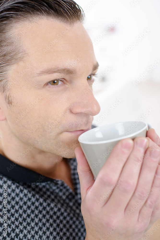 Contemplative man drinking from cup Contemplative man drinking from cup