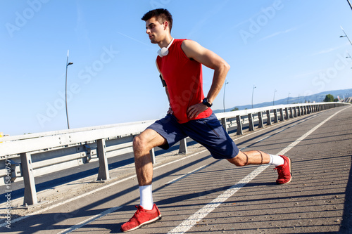 Portrait of young athlete man stretching his muscles before running. © Zoran Zeremski