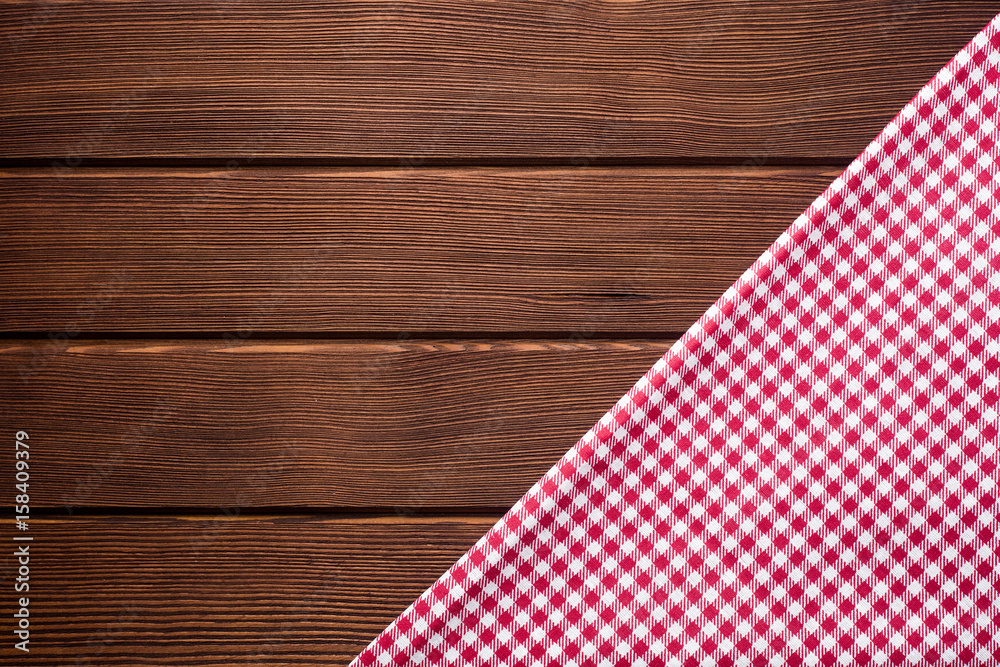 Obraz premium Napkin in a red and white cage on a wooden background, texture, copy space