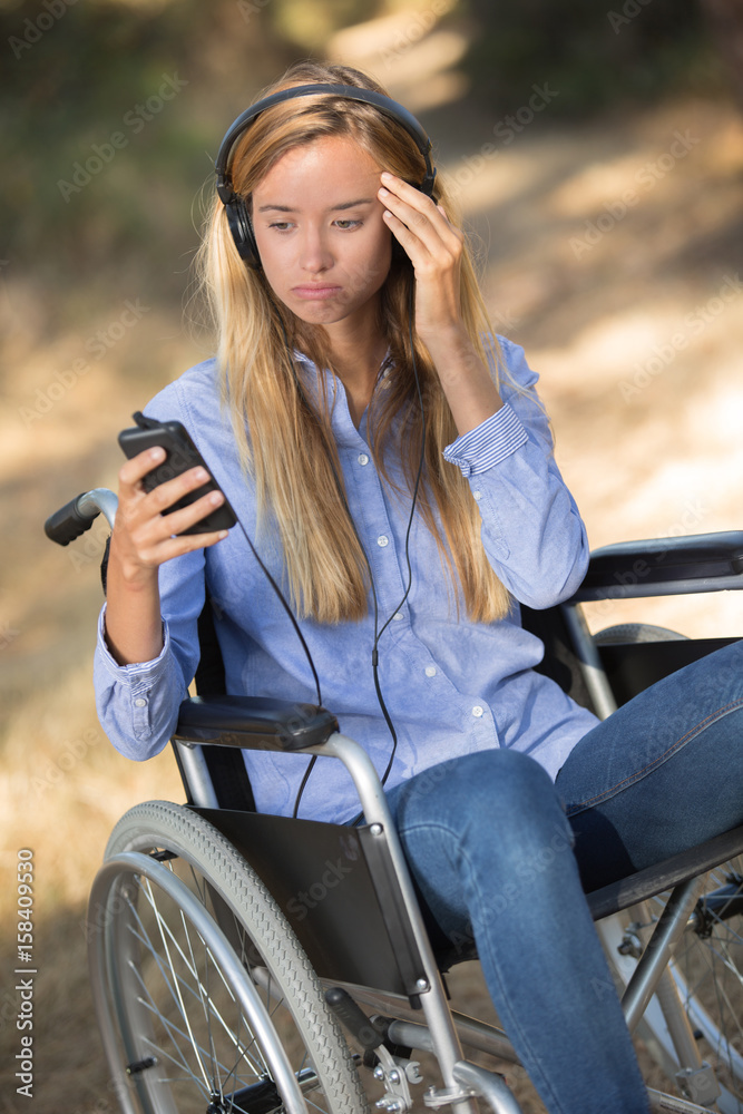 Lady in wheelchair looking in confusion at her cellphone Lady in wheelchair looking in confusion at her cellphone