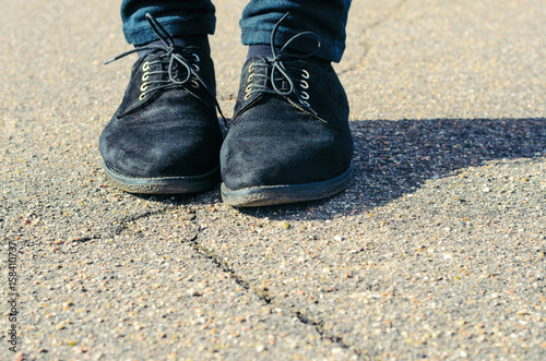 Old Black Female Shoes with Asphalt Background. Female feet standing on road