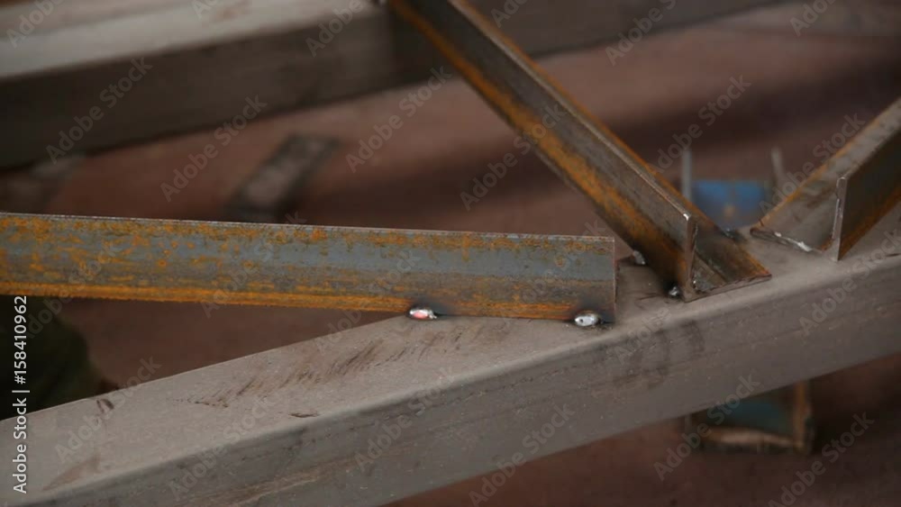 Worker welding a metal construction in a factory. Worker welding a metal construction in a factory.