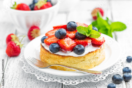 Delicious berry cheesecake with fresh strawberry and blueberry on white background