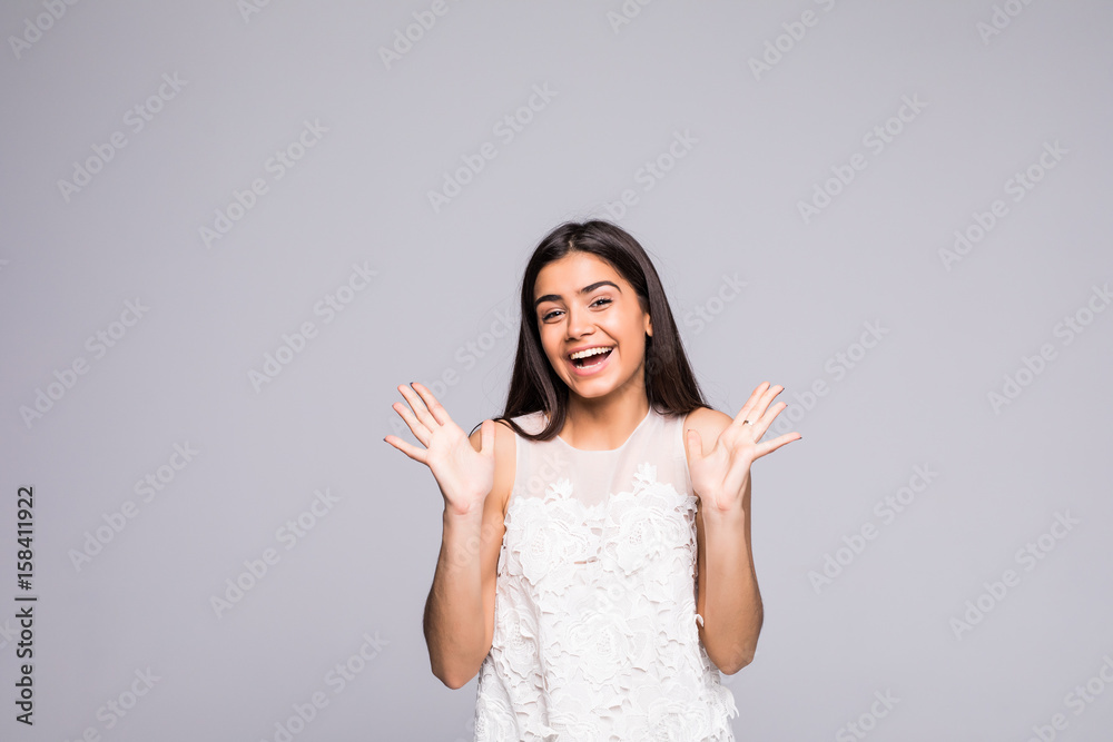 Young beautiful woman with facial expression of surprise standing over gray background. Young beautiful woman with facial expression of surprise standing over gray background.