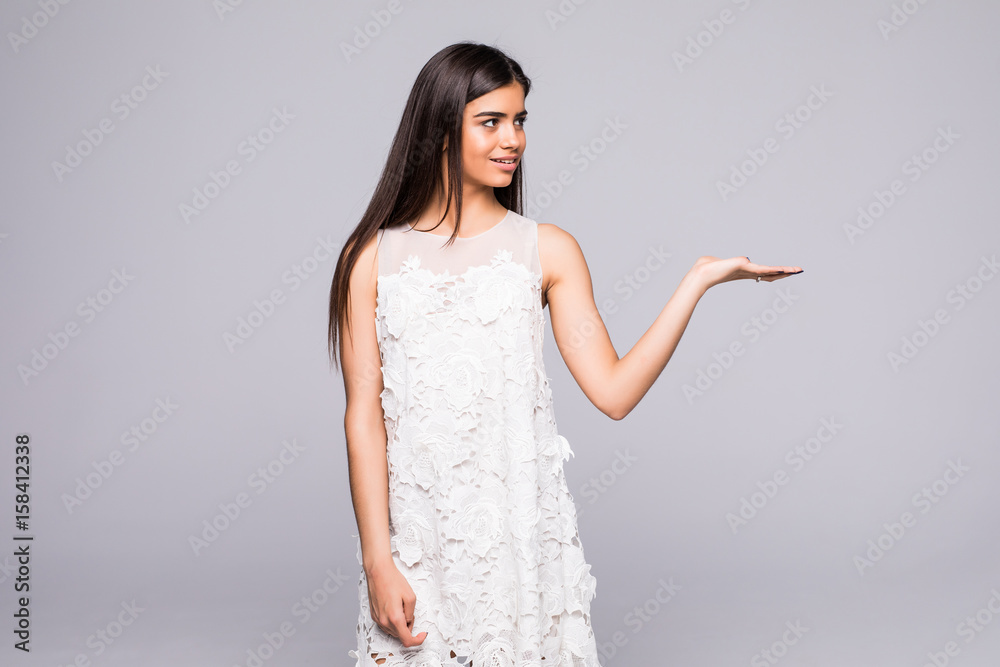 girl holding something invisible on the palms, woman isolated on a gray background girl holding something invisible on the palms, woman isolated on a gray background