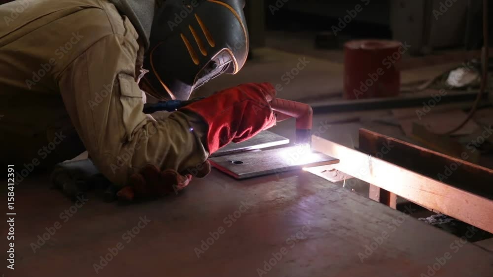 A worker manually cuts metal using manual plasma torch