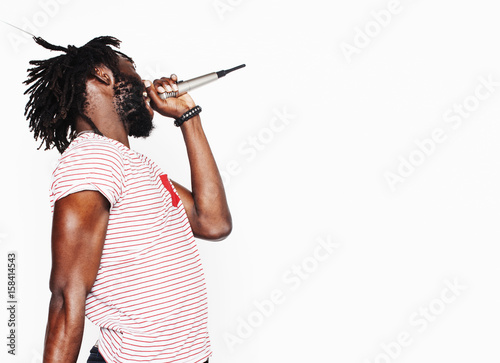 young handsome african american boy singing emotional with microphone isolated on white background, in motion gesturing smiling, lifestyle people concept 