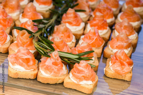 mini canapes with smoked salmon and rosemary sprig.