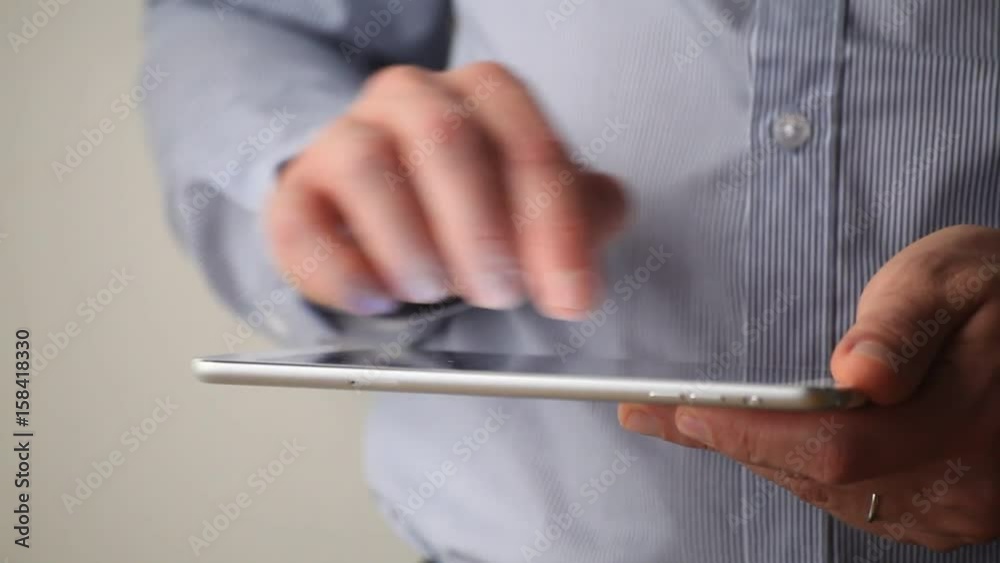 closeup of male hands using application on digital tablet computer closeup of male hands using application on digital tablet computer