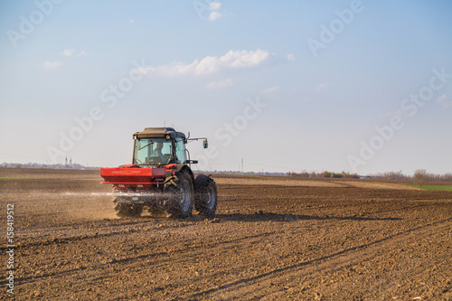 Farmer fertilizing arable land with nitrogen  phosphorus  potassium fertilizer