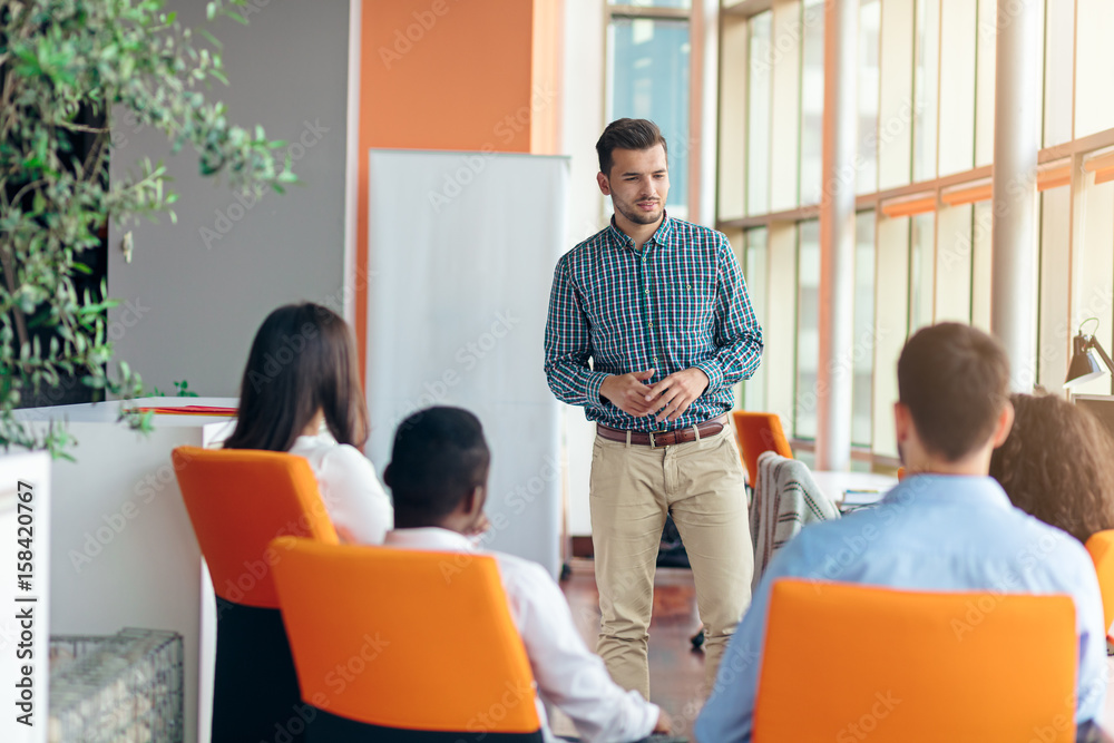 business, startup, presentation, strategy and people concept - man making presentation to creative team at office business, startup, presentation, strategy and people concept - man making presentation to creative team at office
