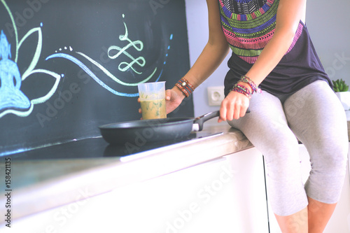 Fitness girl cooking healthy food in the kitchen