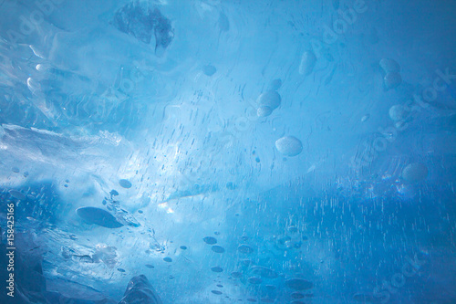 Texture of transparent turquoise blue ice, abstract background, closeup